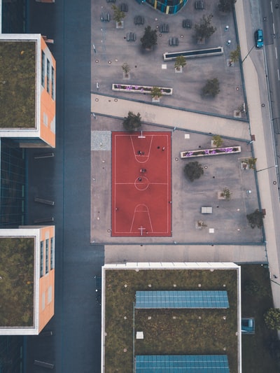 空中摄影中建筑物附近的红色篮球场